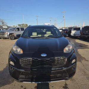 Front view of a black Kia car in a parking lot.