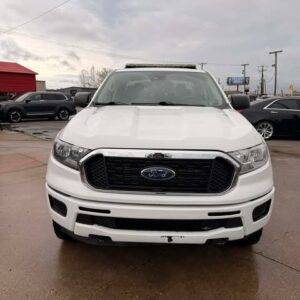 Front view of a white Ford pickup truck in a parking lot.