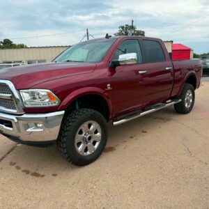 Maroon lifted pickup truck parked in lot